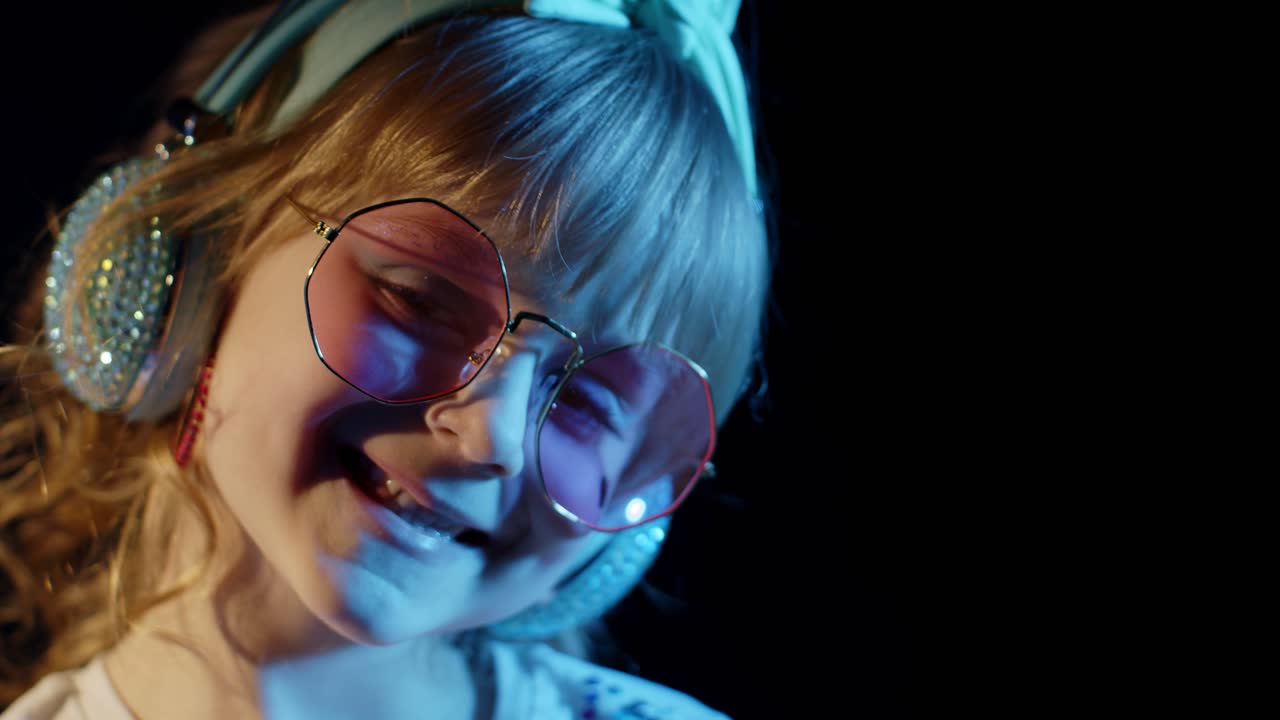 디스코 클럽에서 네온 빛에 미소 짓고 카메라를 보는 트렌디한 세련된 소녀의 초상화