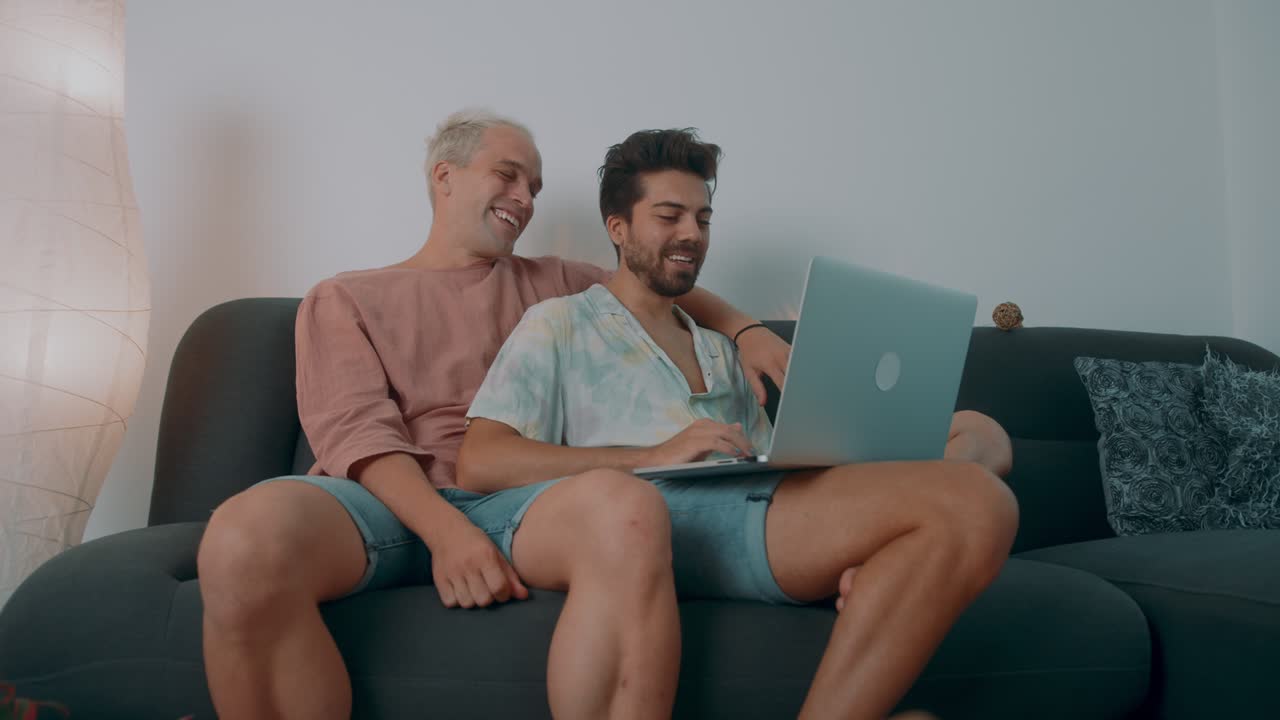 두 남자가 노트북에서 무언가를 보고 있다.