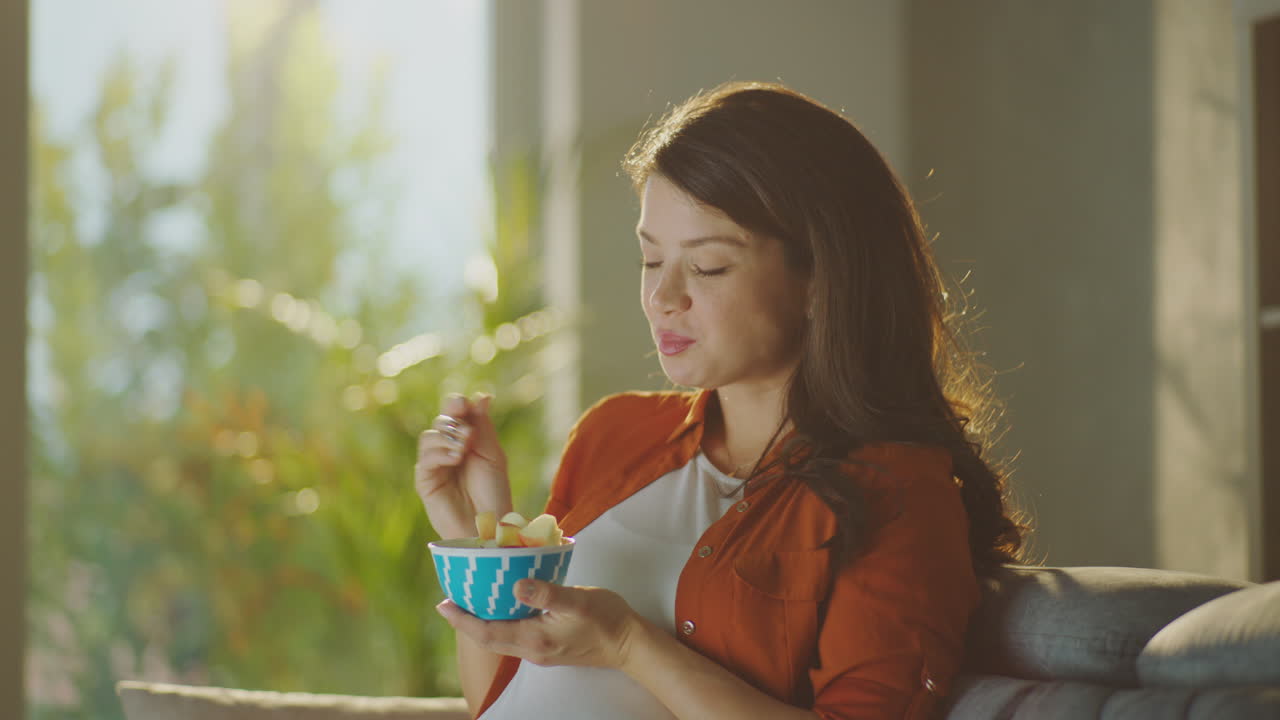 Pregnant woman enjoying fruit salad