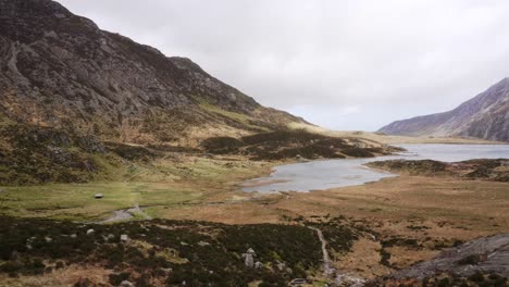 Panning-view-over-Llyn-Idwal,-a-beautiful-lake-in-Snowdonia-National-Park,-North-Wales-on-a-very-windy-day