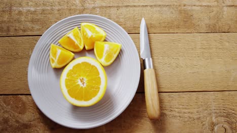 Overhead-of-sweet-limes-in-plate-with-knife