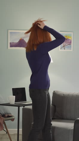 red-haired woman takes packed suitcase with personal clothes and belongings leaving room. upset female person goes away with baggage feeling empty