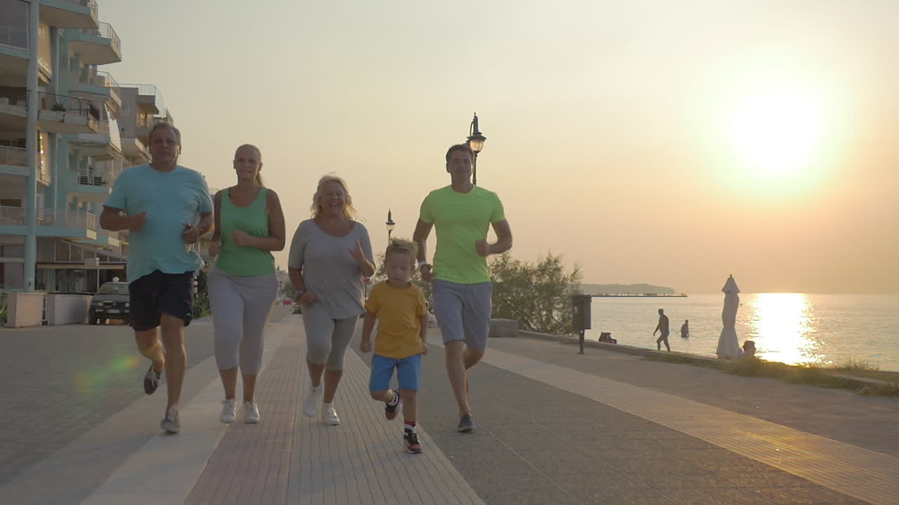 familia amistosa corriendo para terminar en el pavimento al atardecer