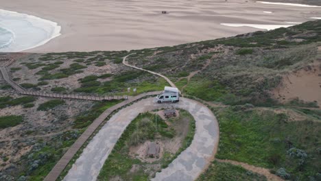 toma orbital aérea alrededor de una autocaravana acampando junto al mar en praia da bordeira en la costa del algarve en portugal