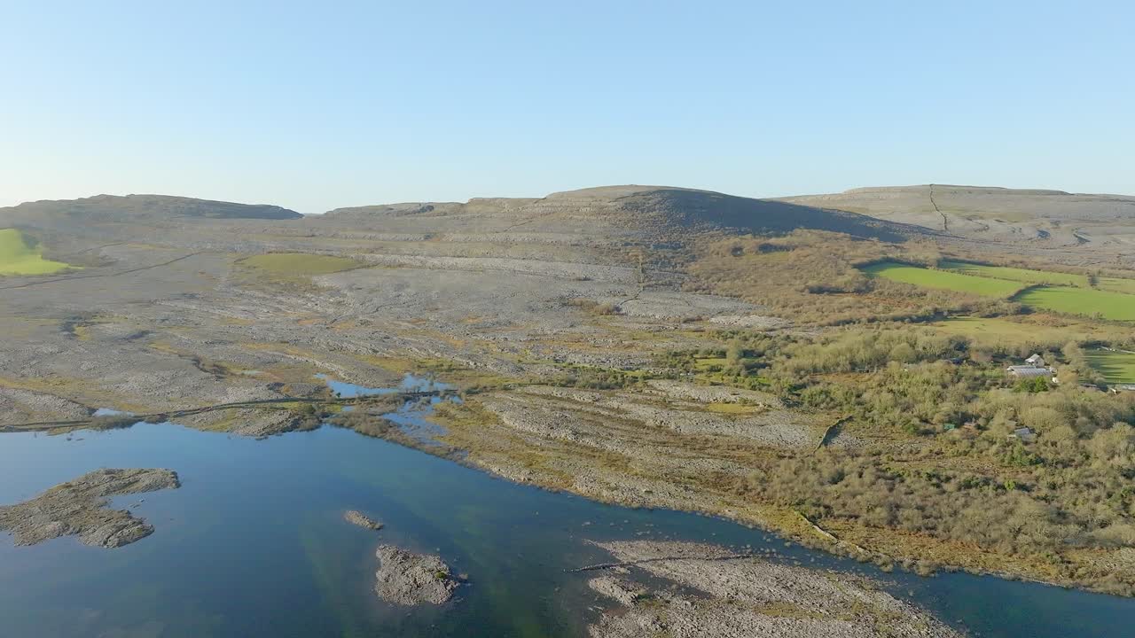 Dolly aereo panoramico che mostra formazioni rocciose geologiche calcaree del Burren, Irlanda, in una giornata di sole
