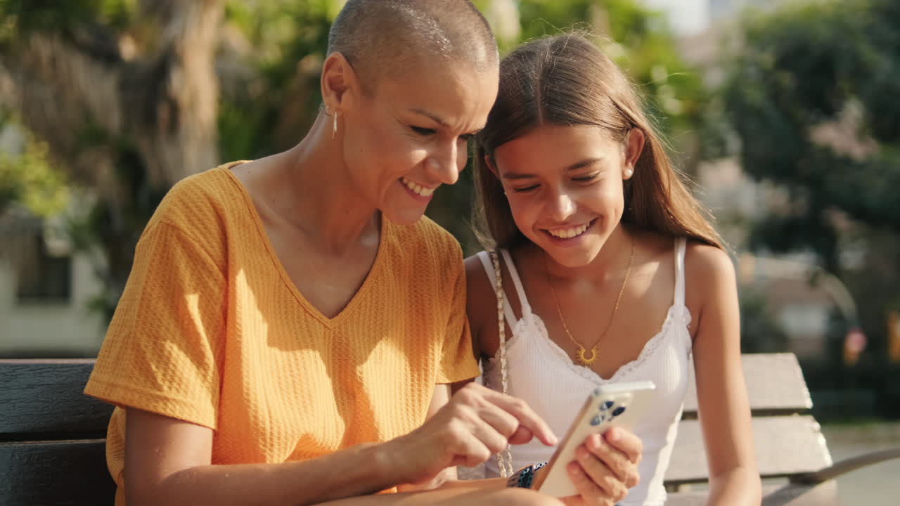 madre e hija disfrutando de un día soleado en el parque