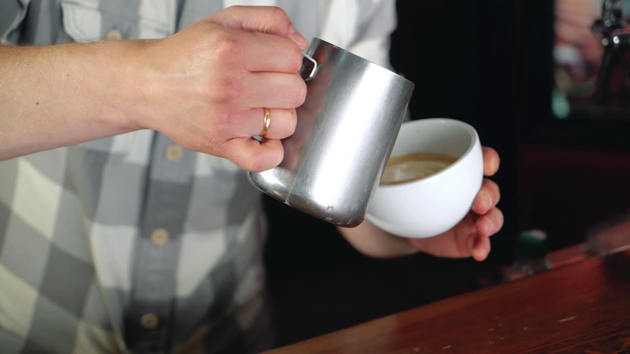 Barista make latte art picture leaf and heart on hot coffee at cafe.