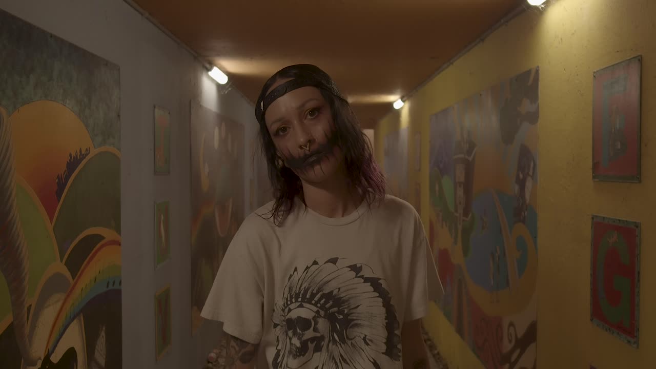 Experience the eerie and mysterious with a female ghoul as she walks down the hall with a mysterious look on her face, showcasing spooky Halloween makeup.