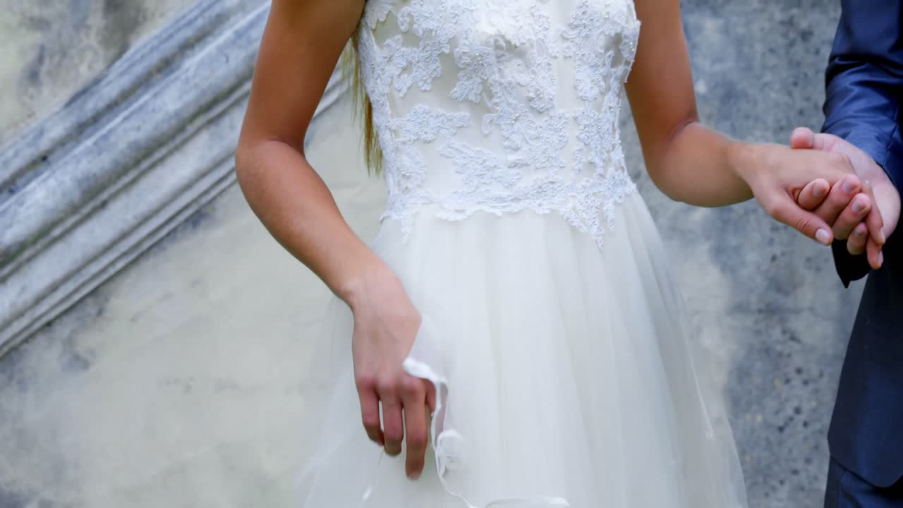 신랑과 신부는 결혼 반지를 착용하여 손을 잡고 있습니다. 4k 4k