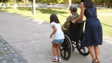 ex soldado retirado discapacitado camuflado caminando con su familia en el parque