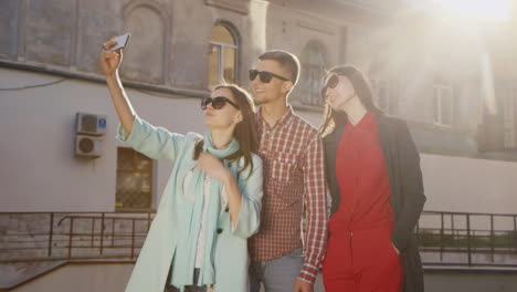 Freunde-Zwei-Frauen-Und-Ein-Mann-Machen-Selfie-In-Der-Sonne-Vor-Dem-Hintergrund-Eines-Alten-Gebäudes-HD-Video