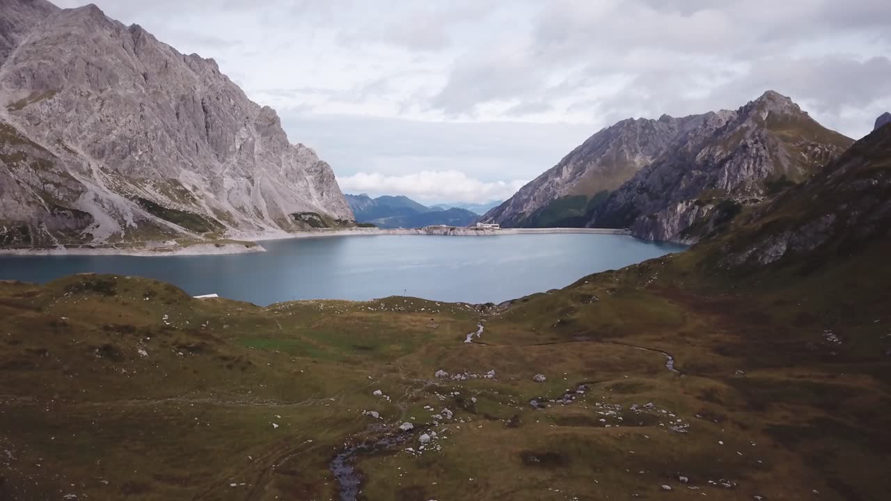 la gente camina en los alpes - vuelo de drones alpes lago lünersee en austria vorarlberg