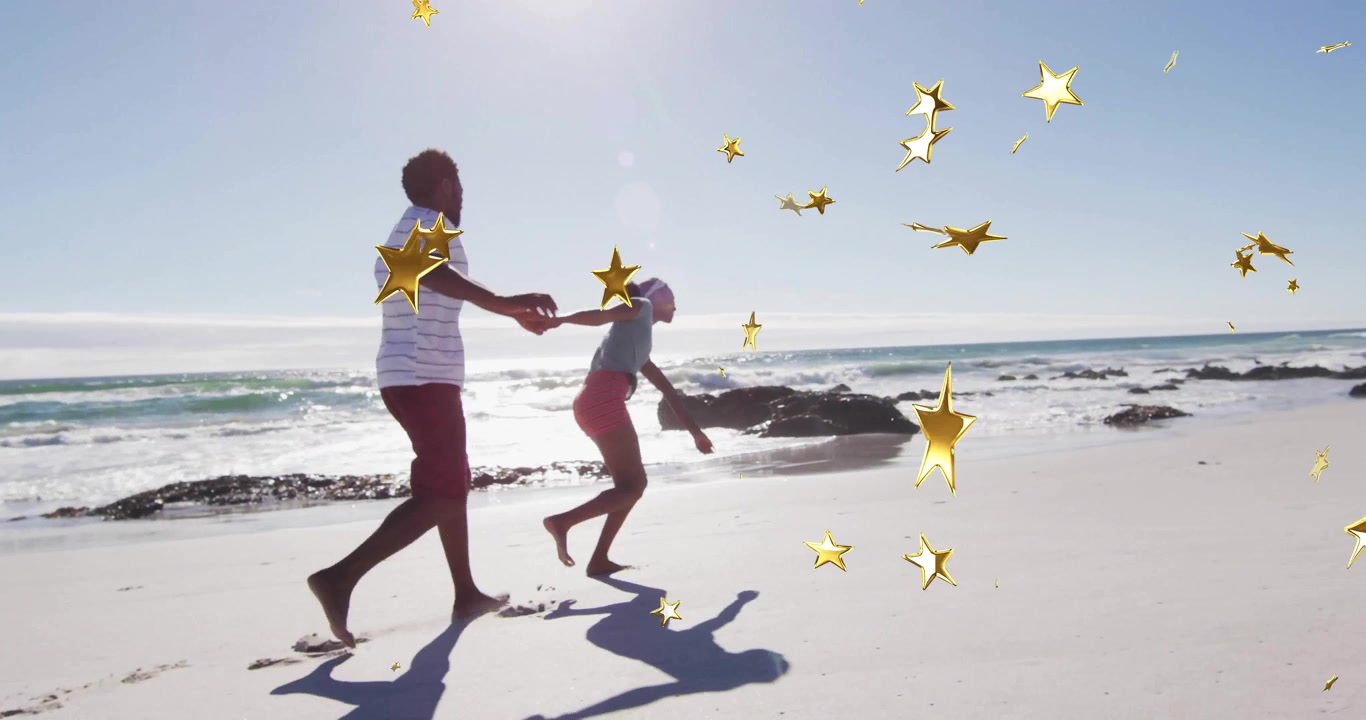 Man extending arm pulling woman into spinning running along beach with star overlays for marketing