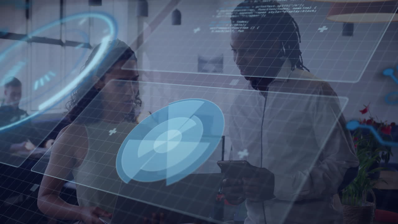 Colleagues examining holographic charts on laptop and tablet in tech office, displaying graphs