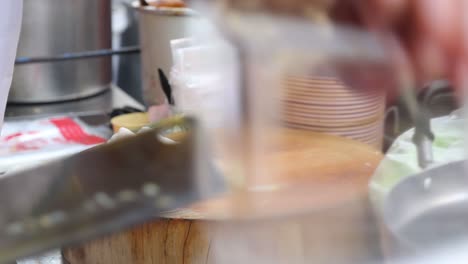el chef corta las envolturas asiáticas en porciones del tamaño de un bocado, de cerca
