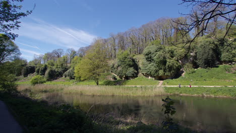 extra wide panning shot looking north across the lake pond at creswell crags, worksop