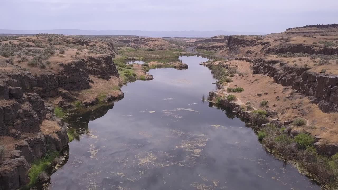 aerial: estanque estancado por una pequeña carretera en escablands canalizados de wa