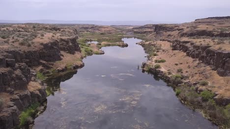 aerial: estanque estancado por una pequeña carretera en escablands canalizados de wa