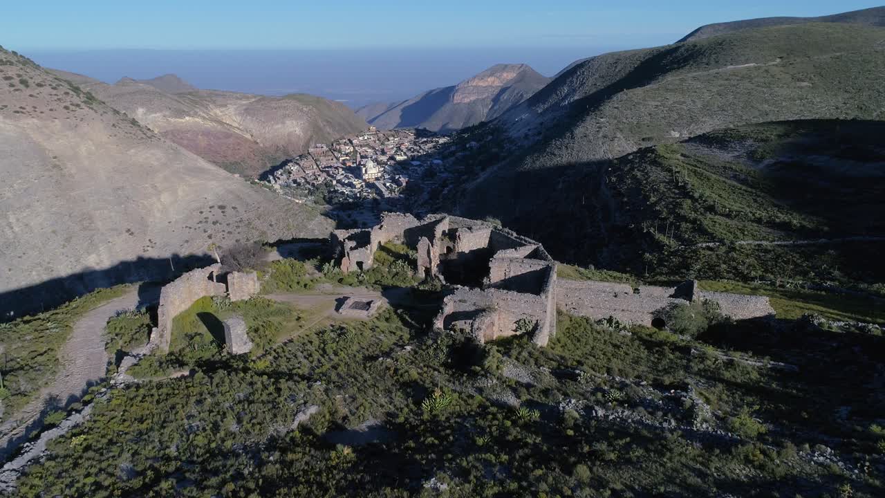 fotografía aérea de las ruinas del antiguo edificio de aduanas en la colina apache con la ciudad real de catorce en la parte posterior, san luis potosi, méxico