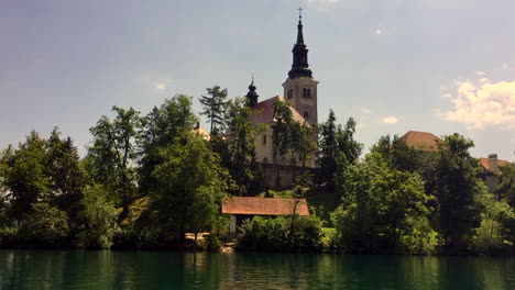 lake bled church of the assumption of mary with bell tower in slovenia, hd, pan from pletna boat to church