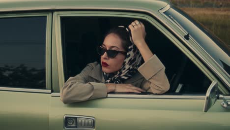 vintage woman driver in a classic green car