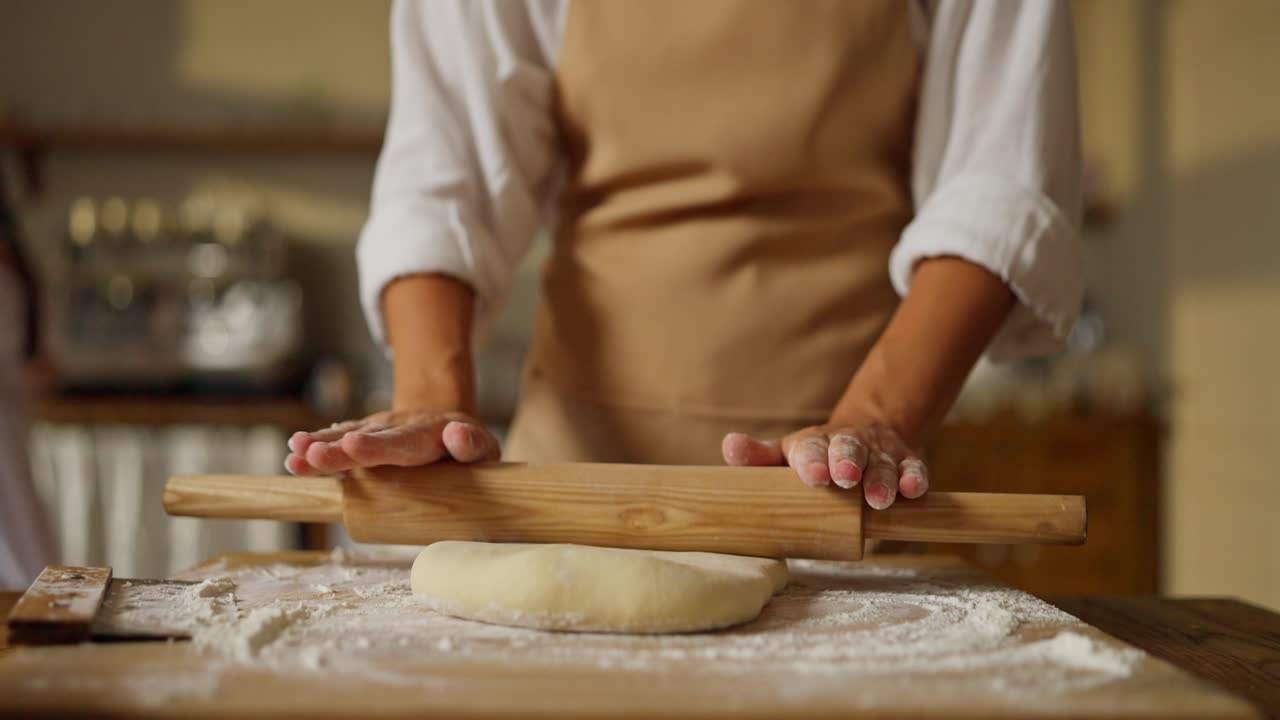Woman Rolling Dough in the Kitchen