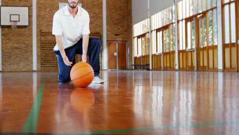 Profesor-De-Deportes-Sosteniendo-Una-Pelota-De-Baloncesto-En-La-Cancha-De-Baloncesto