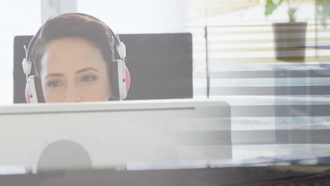 animación de una mujer de negocios biracial usando una computadora sobre personas que caminan y el paisaje urbano