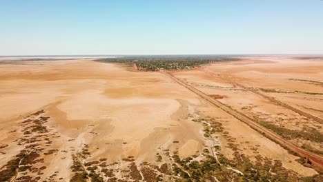 toma aérea larga y ancha de un extenso páramo yermo que rodea la bulliciosa ciudad en medio de la nada
