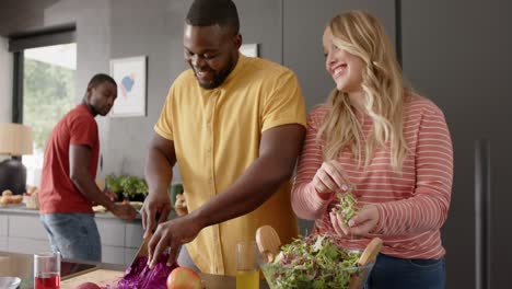 un grupo feliz y diverso de amigos preparando la comida en la cocina, cámara lenta