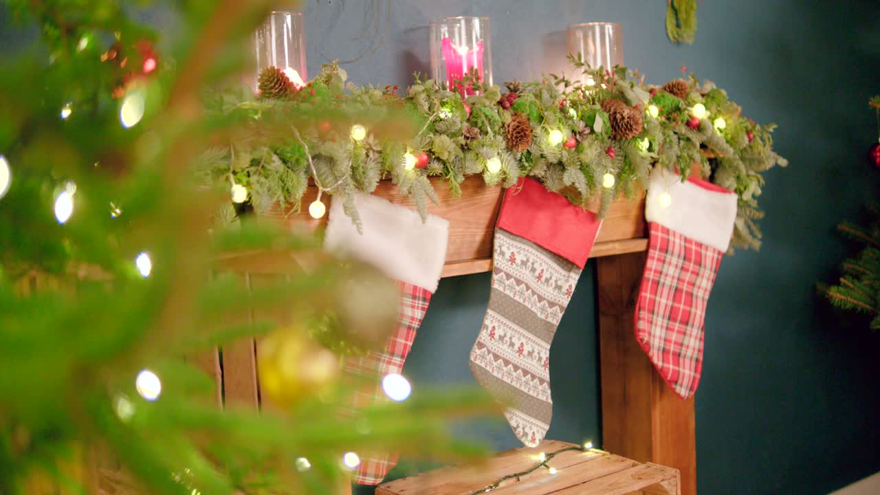 árbol de navidad junto a medias colgadas en muebles de madera a la espera de ser llenados