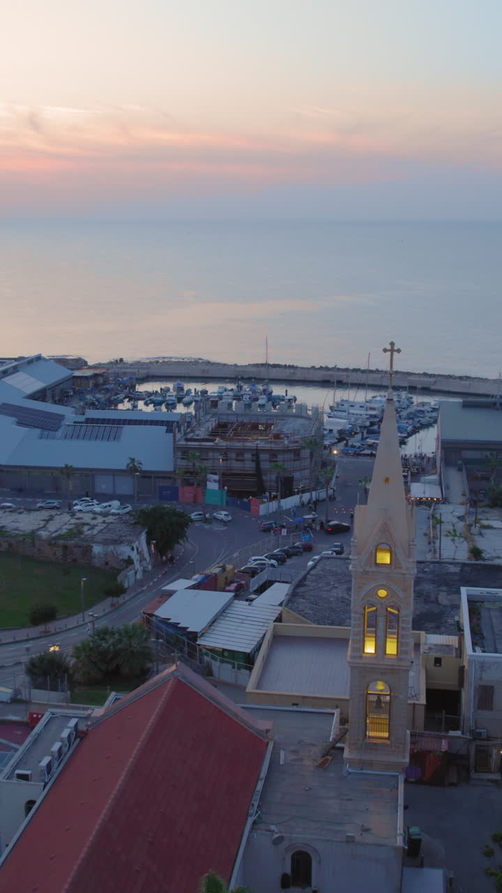 One of the largest churches in the old city of Jaffa at sunset - Jaffa Port in the background - Vertical video