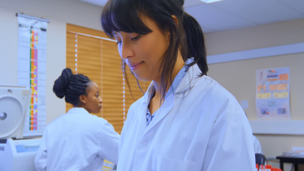 Scienziata che usa un tablet digitale in laboratorio 4k