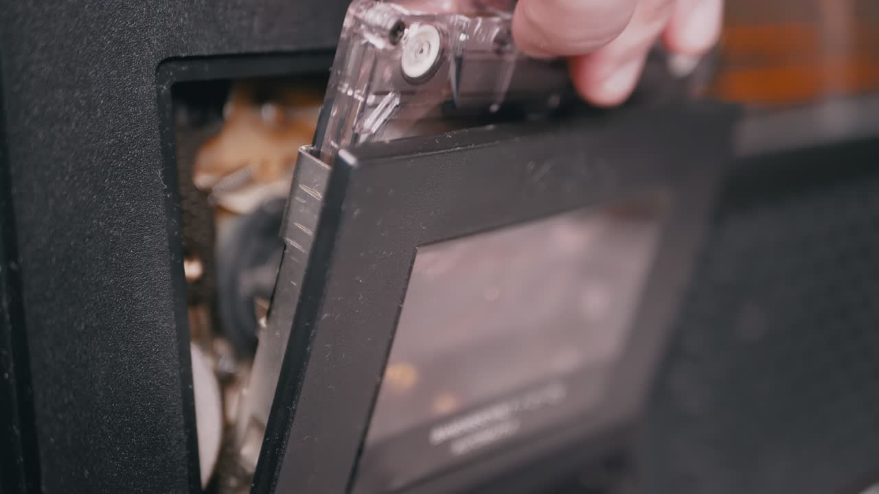 manos femeninas sacan un viejo cassette de audio de una grabadora de cinta vintage. 4k