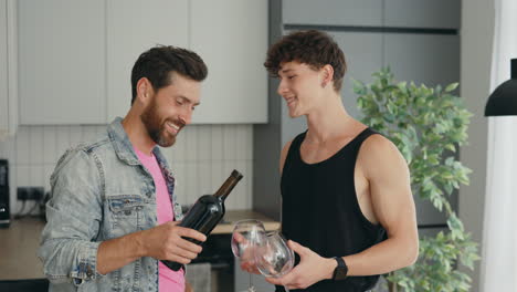 two men enjoying a bottle of wine in a kitchen