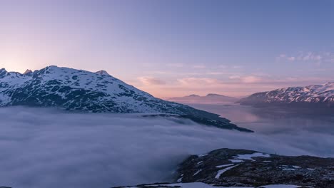 Ein-Zeitraffer-Von-Nebel,-Der-Während-Der-Mitternachtssonne-Von-Einem-Fjord-Zum-Anderen-In-Nordnorwegen-Fließt