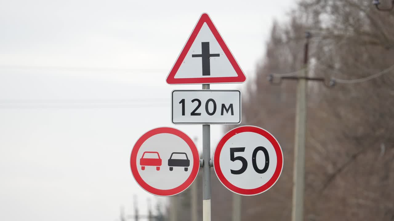 límite de velocidad para los automóviles de 50 kilómetros por hora. no pasar. no adelantar. señal de tráfico en la carretera. atención en el camino. 50 km h. automóviles que se mueven a lo largo de la carretera junto a una señal de límite de velocidad de 50km h. cruce de carretera delante. señal roja de carretera. leyes de tráfico