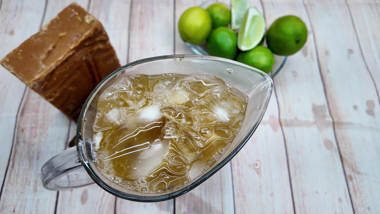 Top-down view of amber-colored panela-based juice being poured from mason jar for ultimate heat relief