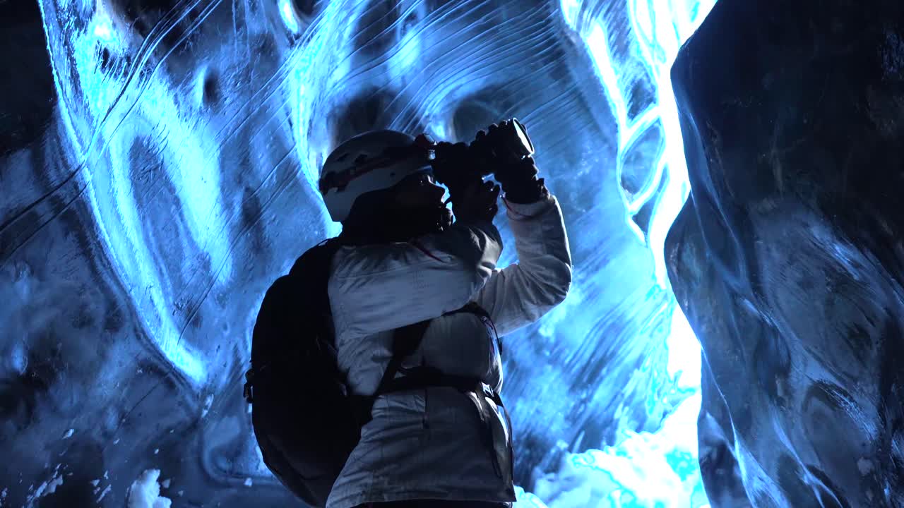 Fotografo in una grotta di ghiaccio