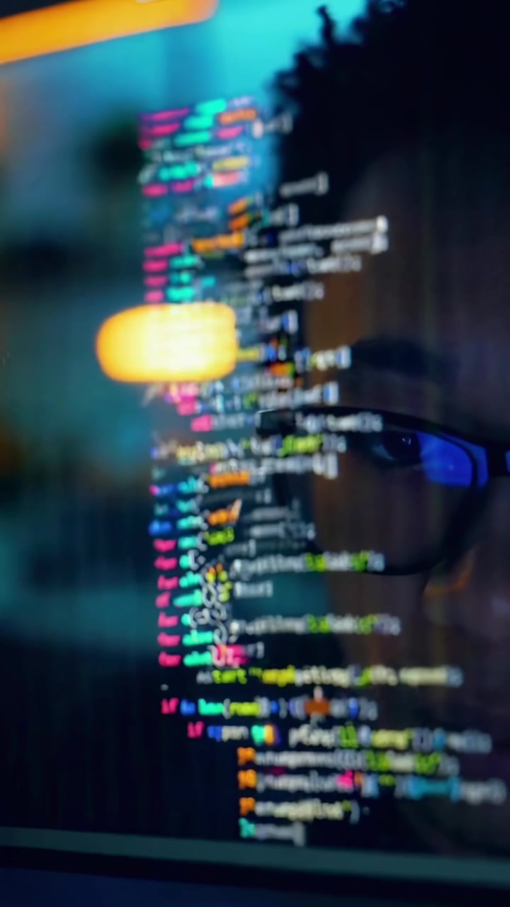 Programmer Typing Code on a Computer Screen at Night