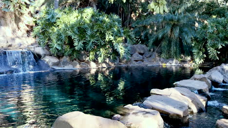 slo-mo pan shot of stone pathway with flowing waterfall and peaceful pond, toowoomba queensland