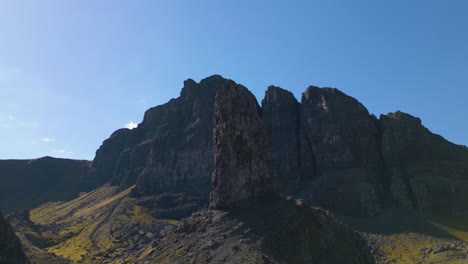 Aerial-circling-Bodach-an-Stoir,-The-Old-Man-of-Storr-on-sunny-day,-Scotland