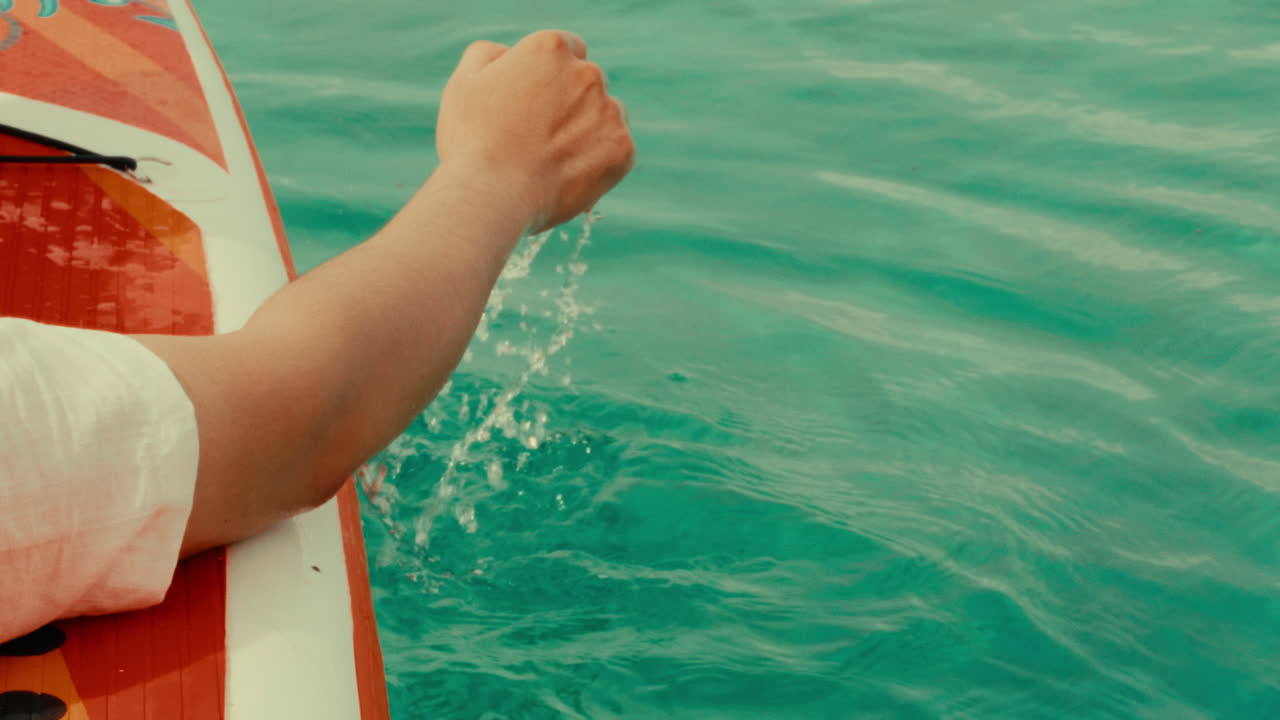 Person paddleboarding in turquoise water
