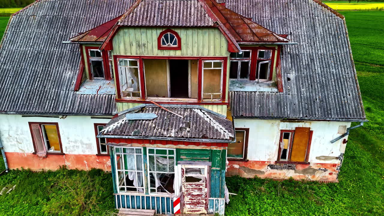 Dilapidated Exterior Of Old Two-Story House On Green Fields. drone pullback ascend