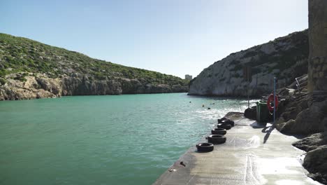 Turquoise-Magrr-Ix-Xini-Bay-Sea-Water-Washes-Stone-Pier-Filled-with-Rubber-Tires