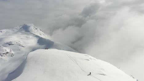 Vista-Muy-Cinematográfica-De-Excursionistas-En-La-Cima-De-Una-Montaña-Nevada-Cerca-De-Pemberton-En-Columbia-Británica,-Canadá