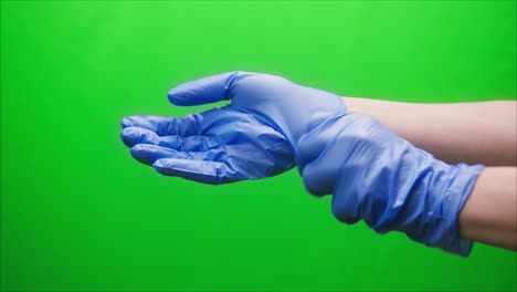 close-up of doctor hands wearing blue medical gloves for safety protection green background, vaccine against coronavirus, vaccination against covid-19, laboratory research concept