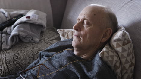 elderly man sleeping on a couch