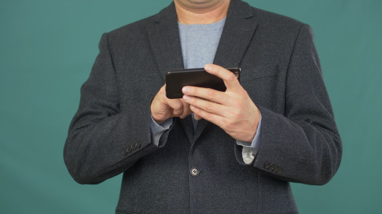 초록색 배경 에 휴대 전화 화면 을 사용 하는 사업가