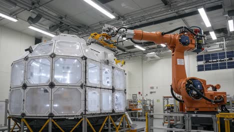 a robotic arm engages with a futuristic space habitat module in a high-tech laboratory environment, showcasing advanced automation in space exploration technology